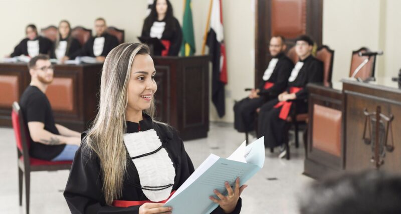 Formanda de Direito sorrindo durante cerimônia de colação de grau.