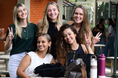 Grupo de estudantes da Unoeste reunidas no campus, sorrindo e interagindo em área de convivência.