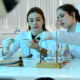 Duas cientistas em laboratório analisando amostra em placa de Petri.