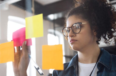 Estudante organizando ideias em notas adesivas coloridas durante atividade de planejamento e construção de mapa mental.