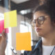 Estudante organizando ideias em notas adesivas coloridas durante atividade de planejamento e construção de mapa mental.