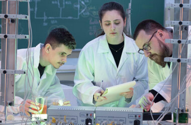 Você sabe o que é engenharia química? Leia o post e descubra muito além disso! Na foto, um aluno e uma aluna juntamente ao professor em aula no laboratório.