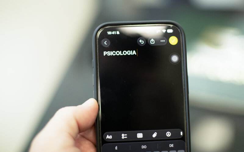 Pessoa segura um celular com a palavra “Psicologia” digitada na tela de um aplicativo de anotações.