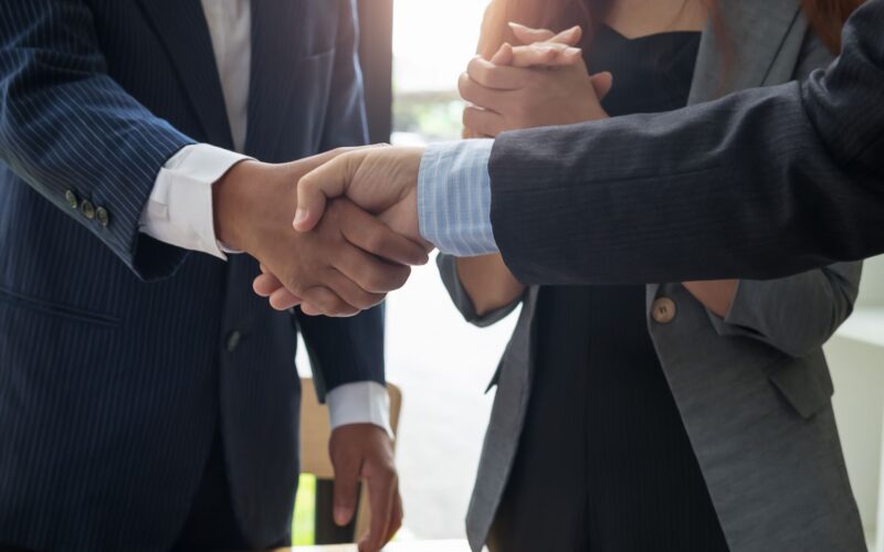 Administradores apertando as mãos e fazendo negócio