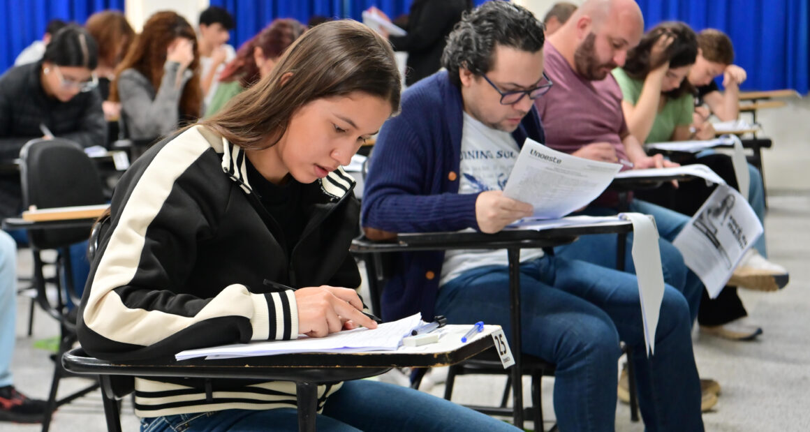 Candidatos realizam prova do vestibular da Unoeste em sala de aula, concentrados na leitura e resolução das questões.