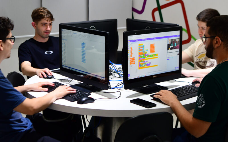 Alunos universitários em aula prática em laboratório de informática.