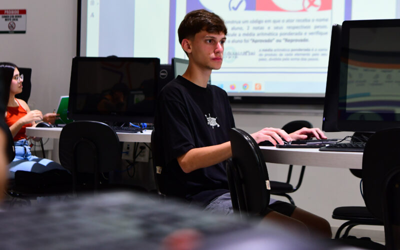 Estudante de Sistemas de Informação durante aula prática em laboratório de informática.