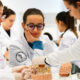 Estudantes de medicina da Unoeste em aula prática, analisando modelos anatômicos do cérebro humano em um laboratório, demonstrando concentração e trabalho em equipe.