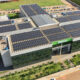 Imagem aérea do campus da Unoeste em Jaú, SP, destacando o prédio moderno com painéis solares no telhado, áreas verdes bem cuidadas ao redor e amplo estacionamento. Uma estrutura que reflete sustentabilidade e excelência acadêmica.