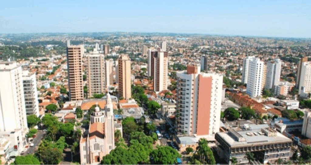 Vista aérea da cidade de Presidente Prudente, São Paulo, Brasil. Diversos prédios e áreas verdes são visíveis.