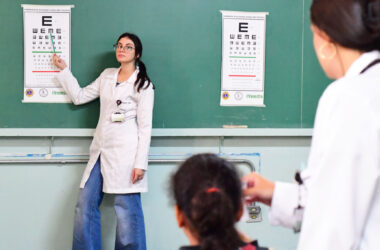 Estudante de Medicina da Unoeste participa da campanha de acuidade visual em escola pública, orientando aluna durante ação do programa de saúde nas escolas. A iniciativa faz parte das atividades de Medicina Preventiva realizadas pela universidade.