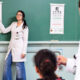 Estudante de Medicina da Unoeste participa da campanha de acuidade visual em escola pública, orientando aluna durante ação do programa de saúde nas escolas. A iniciativa faz parte das atividades de Medicina Preventiva realizadas pela universidade.