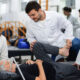 Estudantes e professora do curso de Fisioterapia da Unoeste realizam atendimento a paciente idoso utilizando técnicas de reabilitação física em ambiente clínico universitário.