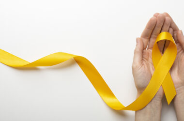 Mãos segurando laço amarelo, símbolo da campanha Setembro Amarelo de prevenção ao suicídio.
