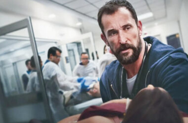 Dr. Michael encara paciente em estado crítico enquanto equipe atua ao fundo, cena intensa da série médica The Pitt da HBO.