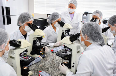 Estudantes do curso de Biomedicina da Unoeste realizam atividades práticas de análises clínicas em laboratório moderno, utilizando microscópios e aplicando técnicas laboratoriais essenciais para a formação em uma das principais áreas da saúde.