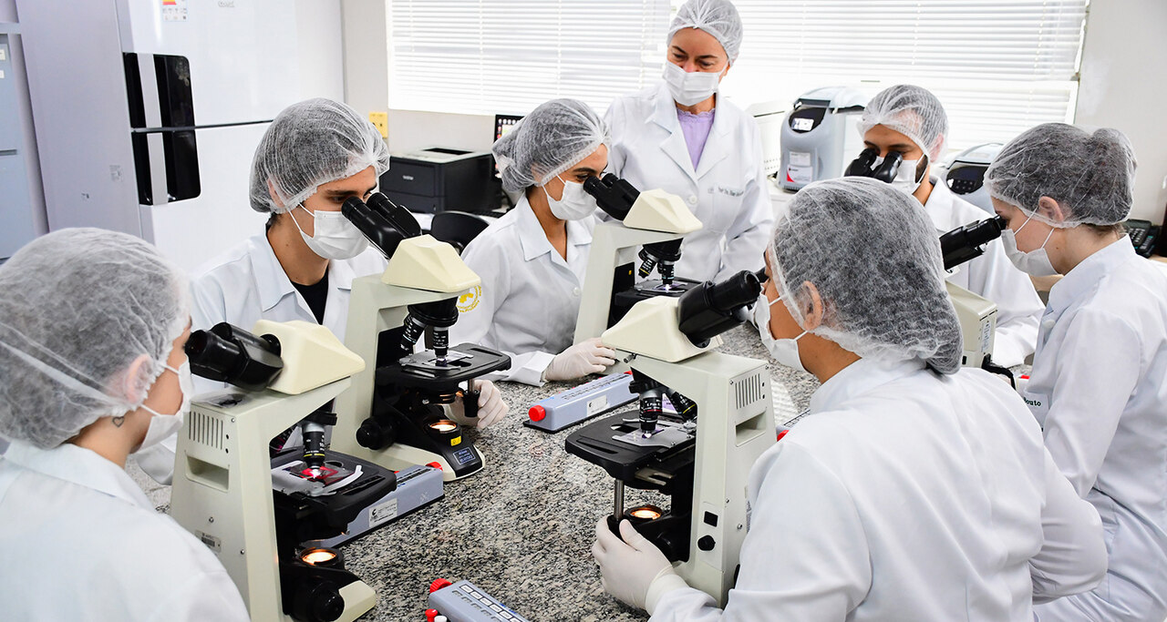 Estudantes do curso de Biomedicina da Unoeste realizam atividades práticas de análises clínicas em laboratório moderno, utilizando microscópios e aplicando técnicas laboratoriais essenciais para a formação em uma das principais áreas da saúde.