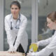 Duas estudantes de Medicina da Unoeste realizam treinamento prático em laboratório: uma executa massagem cardíaca em manequim de simulação, enquanto a outra auxilia com ventilação manual, representando a atuação das mulheres na Medicina.