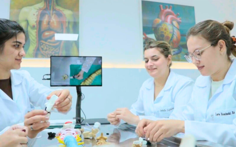 Alunas em laboratório moderno da Unoeste durante aula prática, utilizando recursos tecnológicos e modelos anatômicos. A imagem representa a infraestrutura de ponta e o compromisso da universidade privada com inovação e ensino de qualidade.