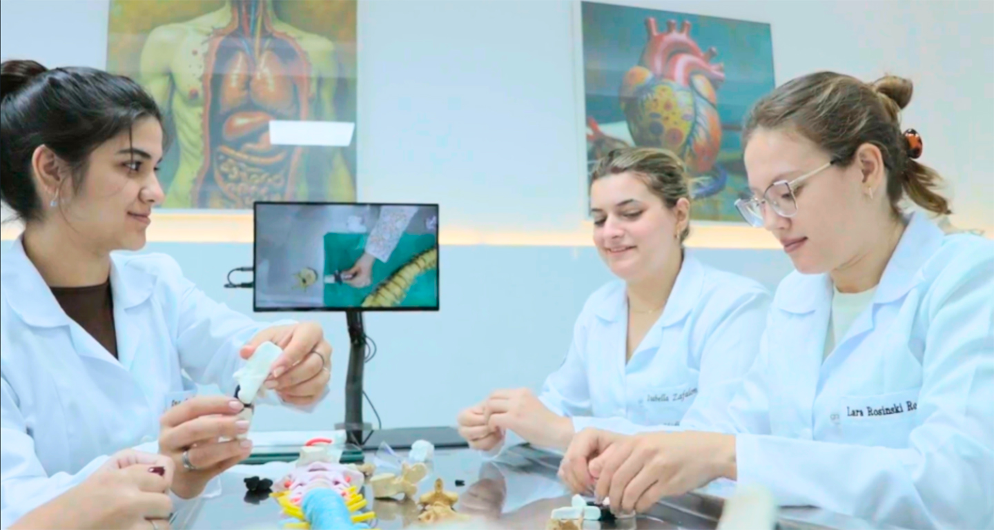 Alunas em laboratório moderno da Unoeste durante aula prática, utilizando recursos tecnológicos e modelos anatômicos. A imagem representa a infraestrutura de ponta e o compromisso da universidade privada com inovação e ensino de qualidade.