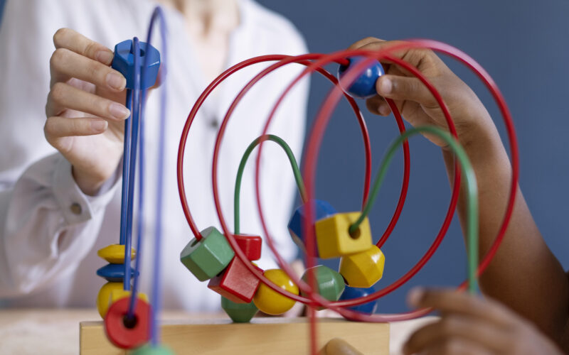 Atividade de Terapia Ocupacional com criança utilizando brinquedo educativo para estímulo da coordenação motora e habilidades cognitivas
