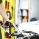 Profissional da área da saúde segurando a maca de uma ambulância, com equipamentos de atendimento pré-hospitalar visíveis ao fundo e interior do veículo desfocado.