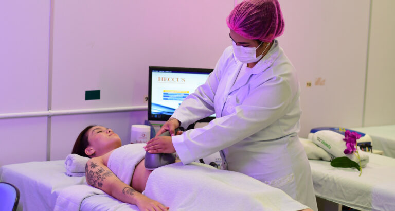 Estudante de Estética e Cosmética da Unoeste realiza procedimento corporal com equipamento em paciente, em clínica-escola da Unoeste, durante aula prática supervisionada.