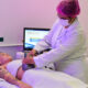 Estudante de Estética e Cosmética da Unoeste realiza procedimento corporal com equipamento em paciente, em clínica-escola da Unoeste, durante aula prática supervisionada.