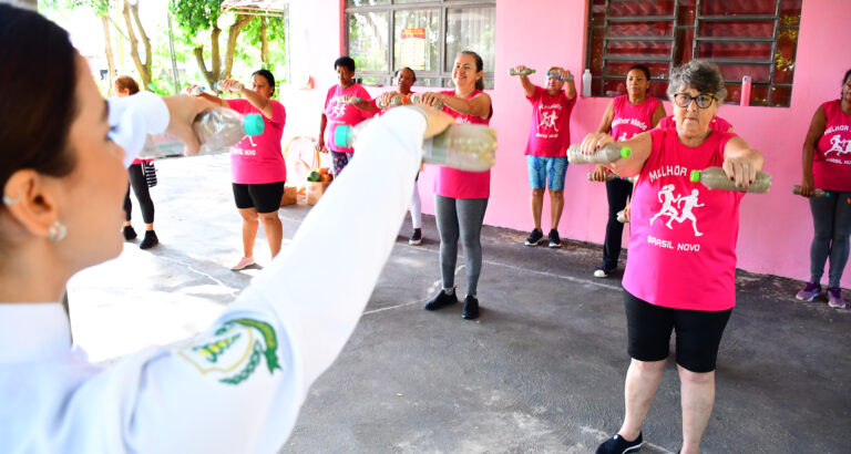 Grupo de pessoas idosas pratica exercícios físicos em ambiente externo, durante atividade voltada à saúde e ao bem-estar na terceira idade.