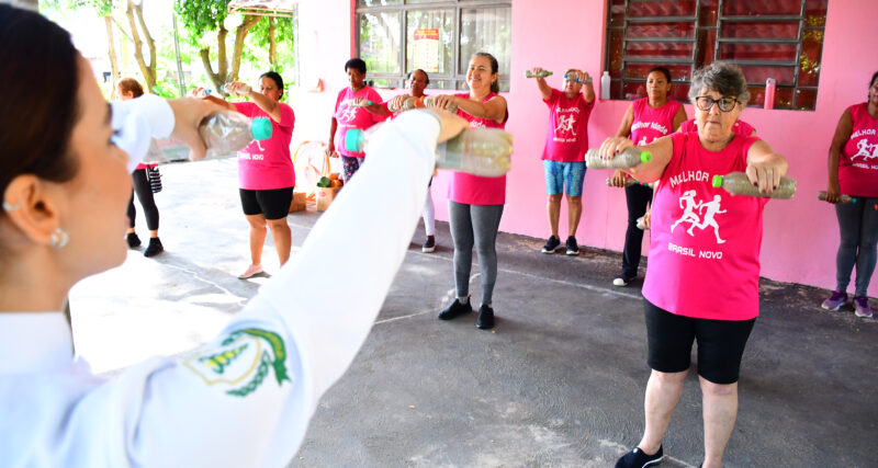 Grupo de pessoas idosas pratica exercícios físicos em ambiente externo, durante atividade voltada à saúde e ao bem-estar na terceira idade.