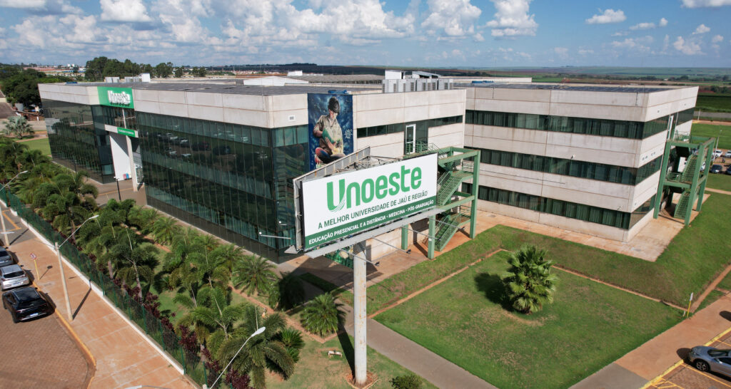 Vista aérea do campus da Unoeste em Jaú, com estrutura moderna, áreas verdes e prédio principal da universidade.