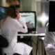 Estudantes de Medicina utilizando computadores e tecnologia digital em ambiente de simulação, demonstrando o uso de recursos tecnológicos e jogos aplicados ao aprendizado médico.