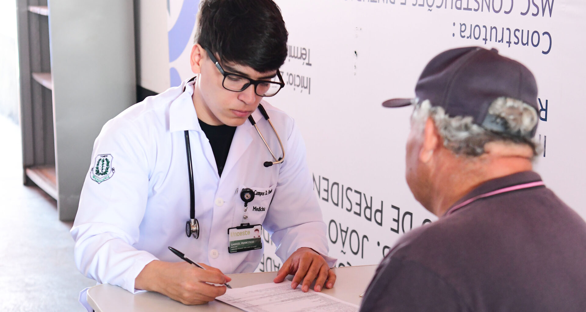 Estudante de Medicina da Unoeste realiza atendimento e coleta de informações de um paciente idoso durante atividade prática voltada ao cuidado humanizado em saúde.