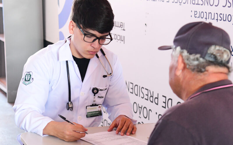 Estudante de Medicina da Unoeste realiza atendimento e coleta de informações de um paciente idoso durante atividade prática voltada ao cuidado humanizado em saúde.