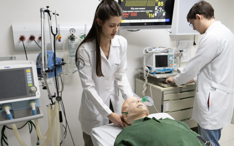 Estudantes de Medicina da Unoeste realizam treinamento em laboratório de simulação clínica, utilizando manequim de atendimento avançado e equipamentos hospitalares para praticar procedimentos de emergência e cuidados intensivos.