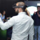 Pessoa utilizando óculos de realidade virtual durante uma apresentação sobre inteligência artificial e inovação tecnológica, enquanto participantes acompanham a demonstração em um ambiente de aprendizagem e tecnologia.
