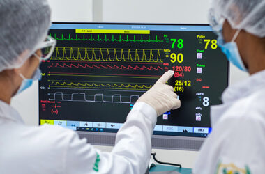 Estudantes de Medicina da Unoeste analisam monitor multiparamétrico durante atividade prática em laboratório de simulação clínica, observando sinais vitais e parâmetros utilizados no acompanhamento de pacientes.