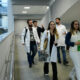 Estudantes de Medicina caminham pelos corredores do campus da Unoeste durante a rotina acadêmica, em ambiente moderno e amplo, que integra espaços de convivência e aprendizagem para a formação médica.
