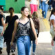 Alunos circulam pelo campus da Unoeste durante o intervalo das aulas, carregando mochilas e bolsas em um ambiente universitário.