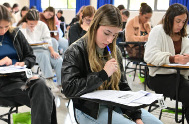 Candidatos concentrados realizam prova de vestibular da Unoeste em sala de aula, sentados individualmente em carteiras e respondendo às questões impressas.