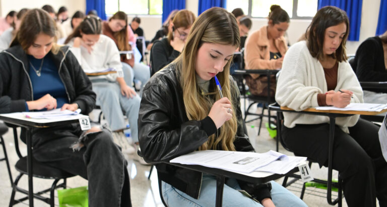 Candidatos concentrados realizam prova de vestibular da Unoeste em sala de aula, sentados individualmente em carteiras e respondendo às questões impressas.