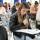 Candidatos concentrados realizam prova de vestibular da Unoeste em sala de aula, sentados individualmente em carteiras e respondendo às questões impressas.