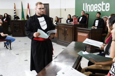 Estudantes do curso de Direito participam de atividade prática em tribunal simulado da Unoeste, com apresentação diante da bancada de julgamento.