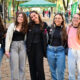 Grupo de jovens posa para foto durante o Vestibular da Unoeste, em área externa do campus decorada com bandeiras verdes da universidade.