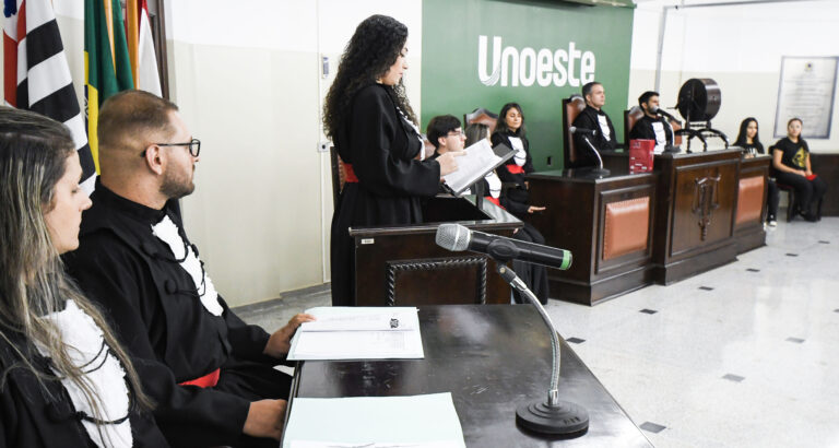 Estudantes do curso de Direito participam de atividade prática em tribunal simulado da Unoeste, com júri, tribuna e bancada de julgamento.