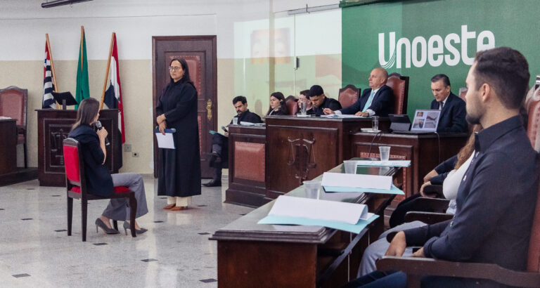 Simulação de julgamento no Tribunal Jurídico da Unoeste, com participantes representando diferentes funções em uma audiência.
