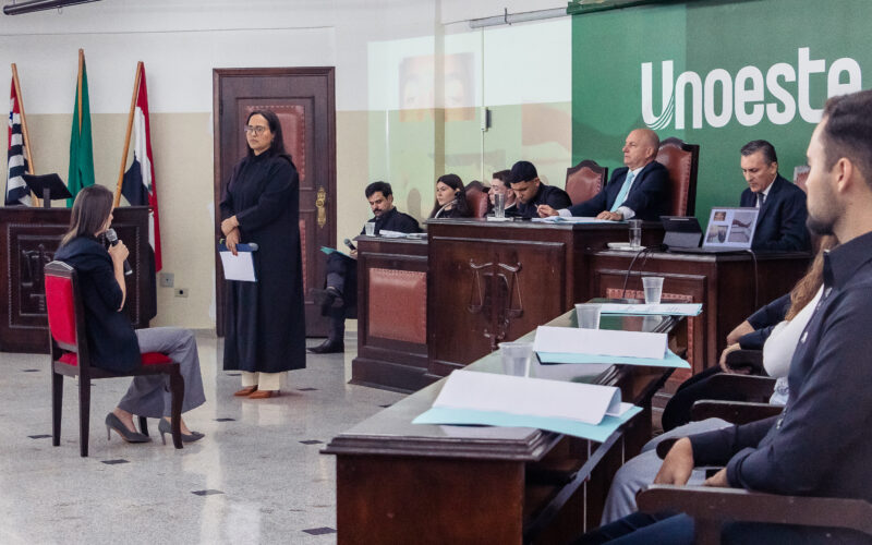 Simulação de julgamento no Tribunal Jurídico da Unoeste, com participantes representando diferentes funções em uma audiência.