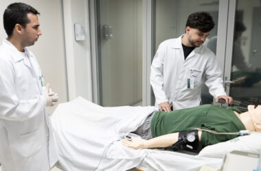 Estudante e professor de Medicina da Unoeste, vestidos com jalecos, realizam treinamento prático com simulador de paciente em laboratório de simulação clínica.