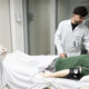 Estudante e professor de Medicina da Unoeste, vestidos com jalecos, realizam treinamento prático com simulador de paciente em laboratório de simulação clínica.