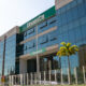 Fachada do campus da Unoeste no Guarujá, com entrada principal, palmeiras e identificação da universidade no prédio.